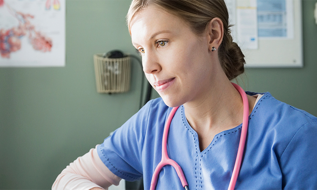 Nurse wearing blue scrubs and a pink stethoscope. 